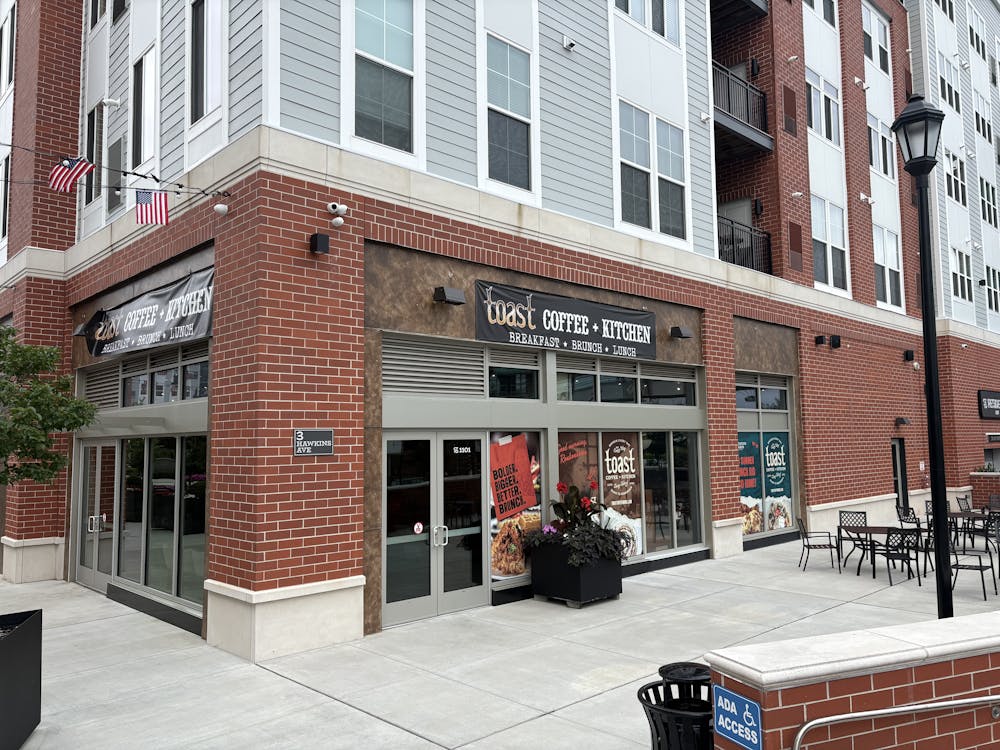 Front facade of brick and glass building with sign for Toast Coffee + Kitchen