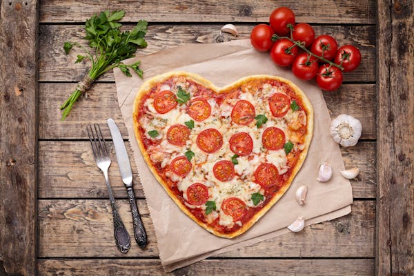 a pizza sitting on top of a wooden cutting board
