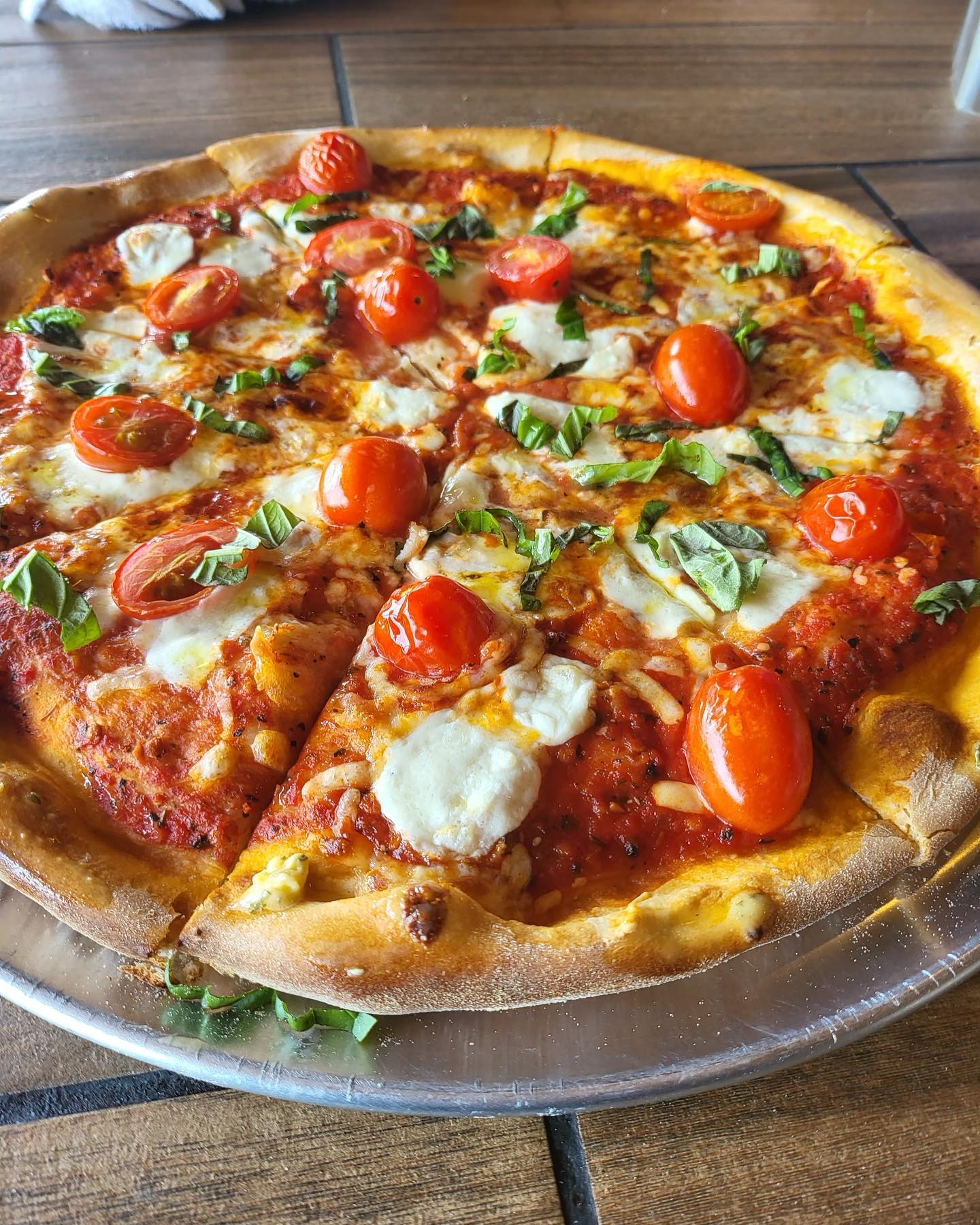 a pizza sitting on top of a wooden table