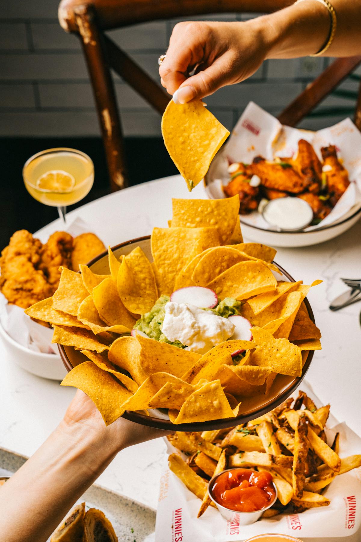 a person holding a plate of food on a table