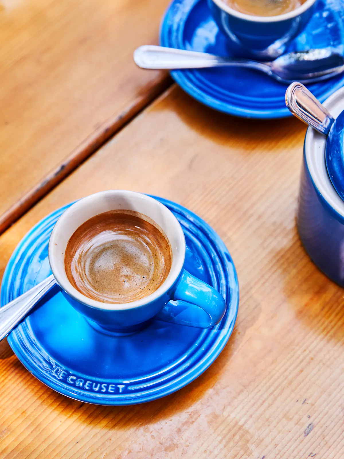 a cup of coffee sitting on top of a wooden table