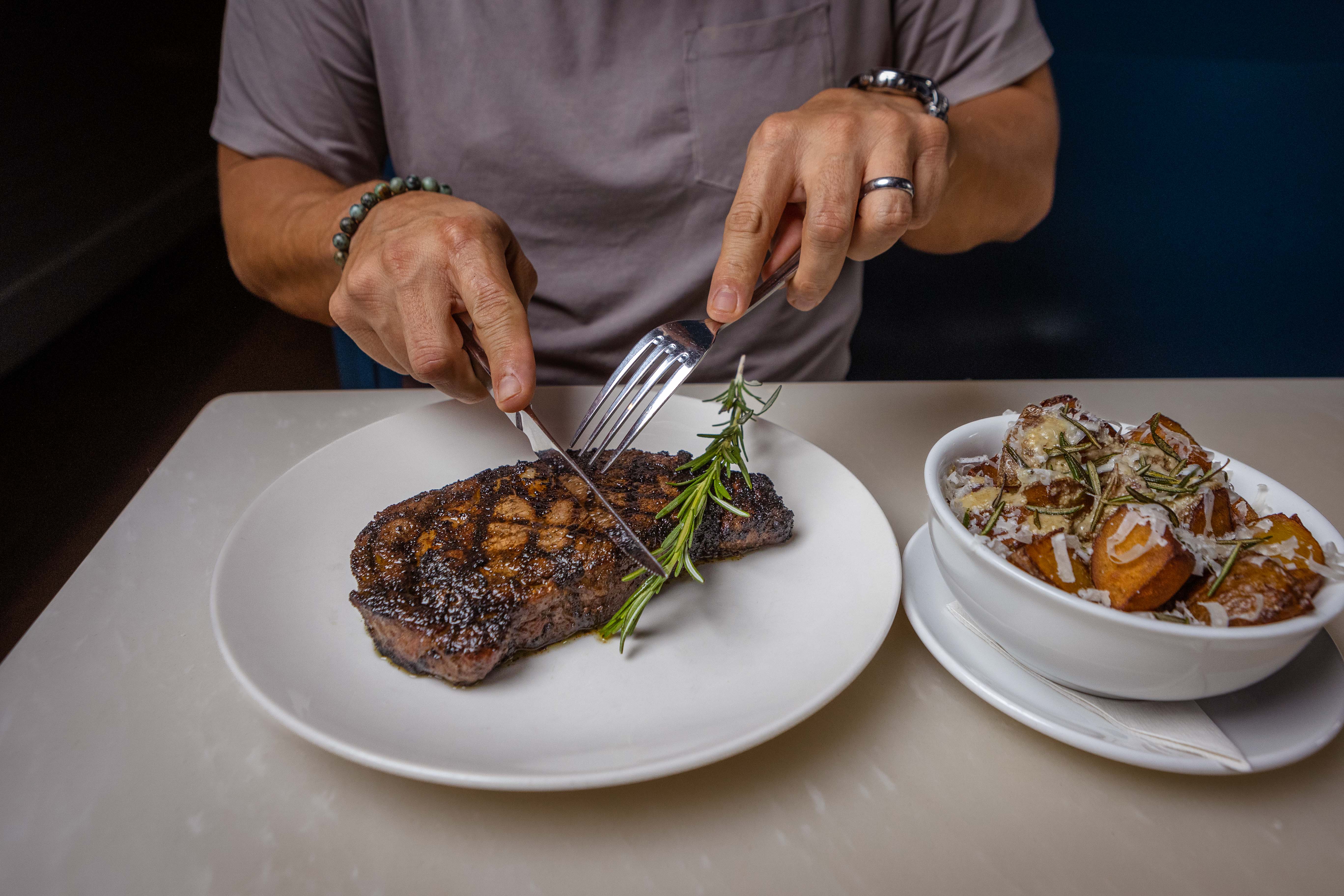 a man holding a plate of food on a table