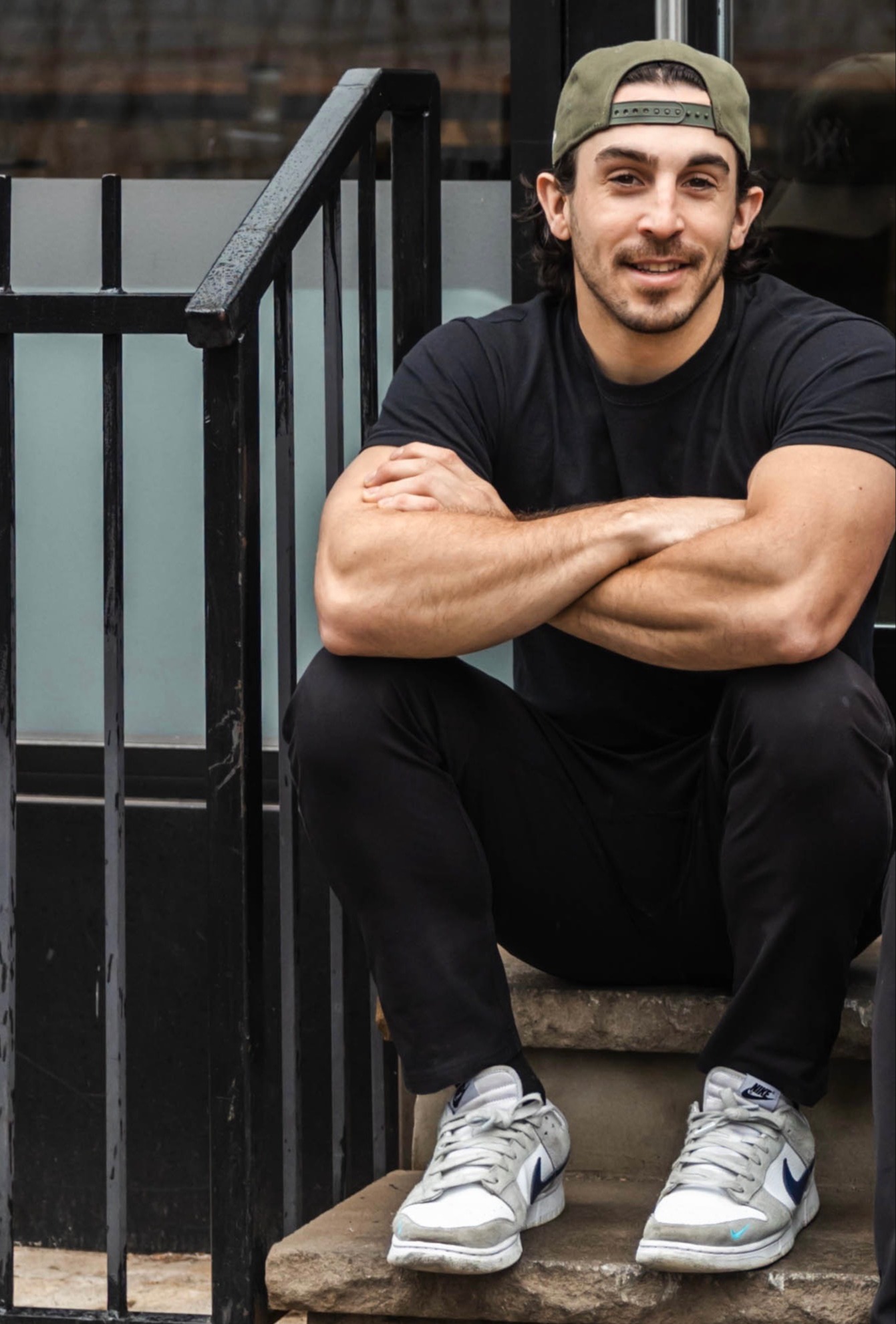 a man sitting in front of a fence