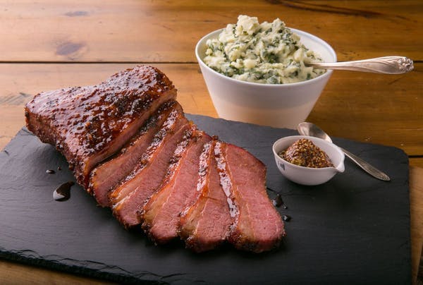 a piece of meat on a cutting board with a cake on a plate