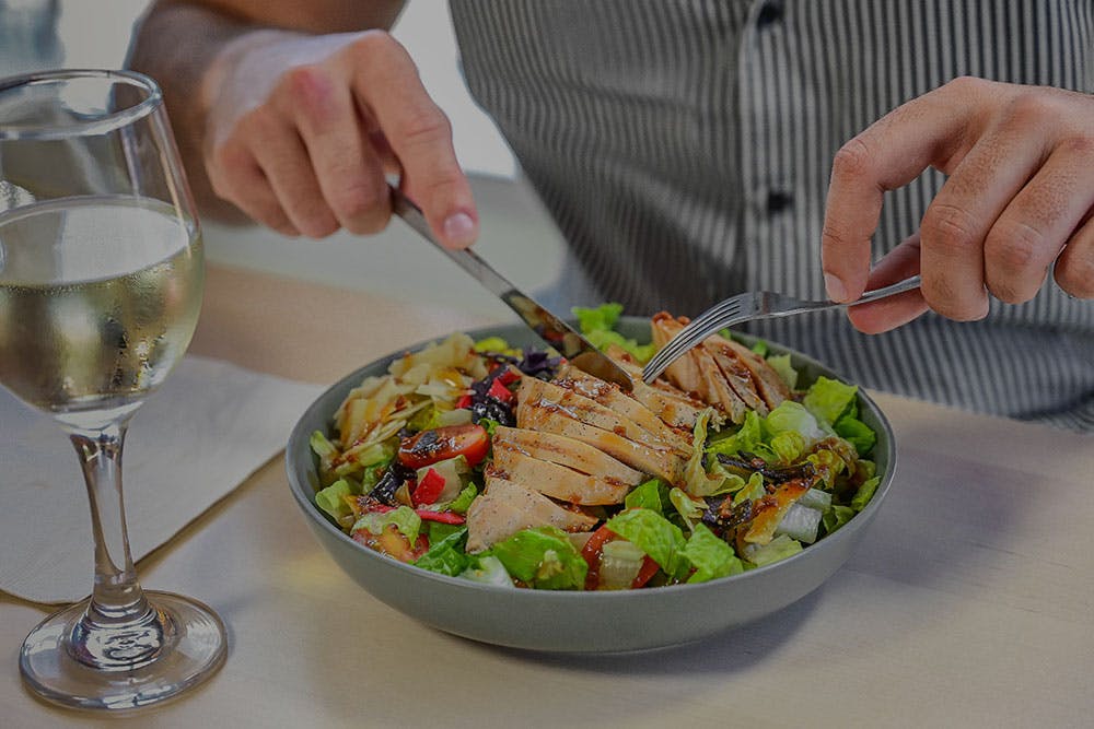 a person sitting at a table with a plate of food
