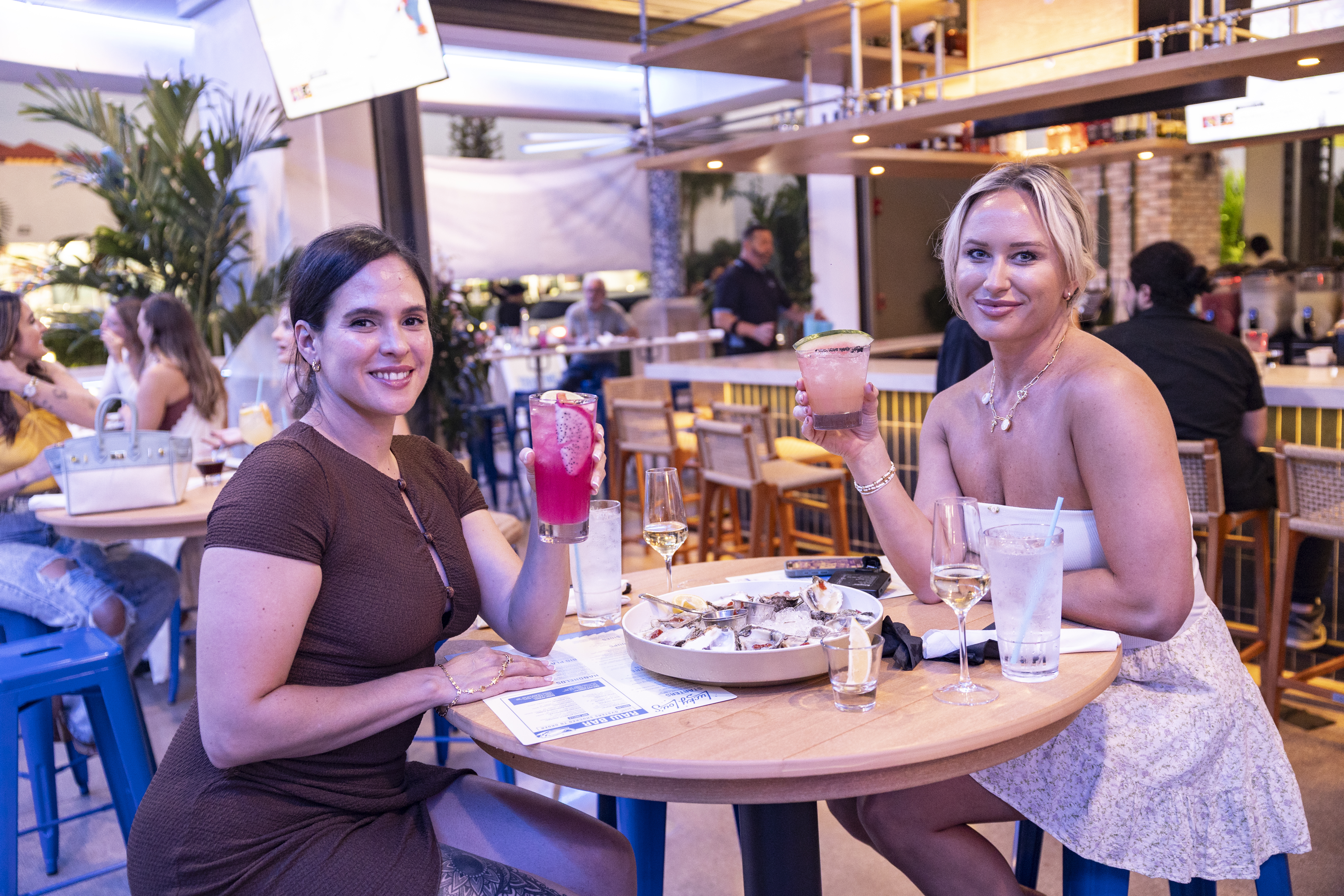 Women dining and holding cocktails at Lucky Lou's