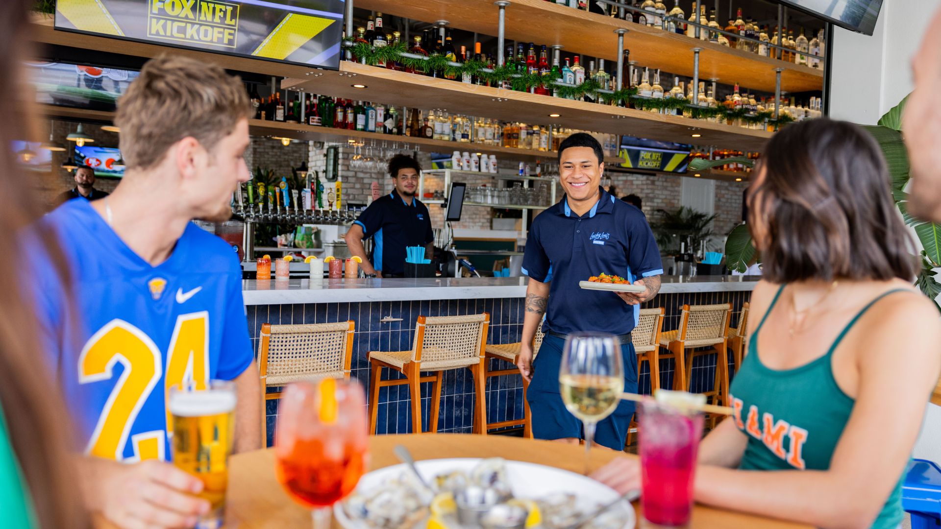 Waiter serving food to sports fans at Lucky Lou's