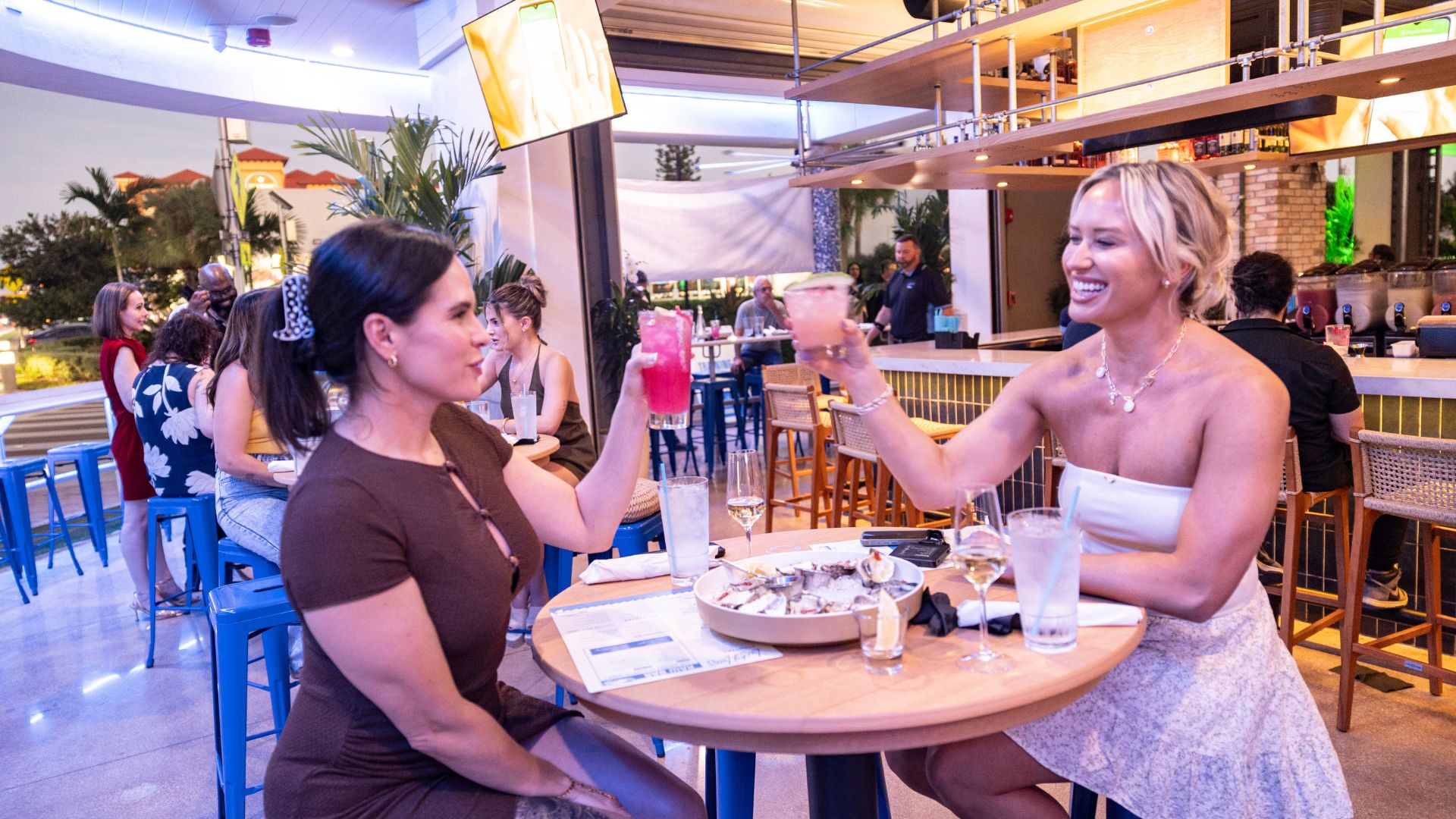 Women clinking drinks and dining at Lucky Lou's