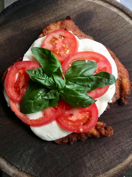 food topped with cheese, tomatoes, and basil on a table