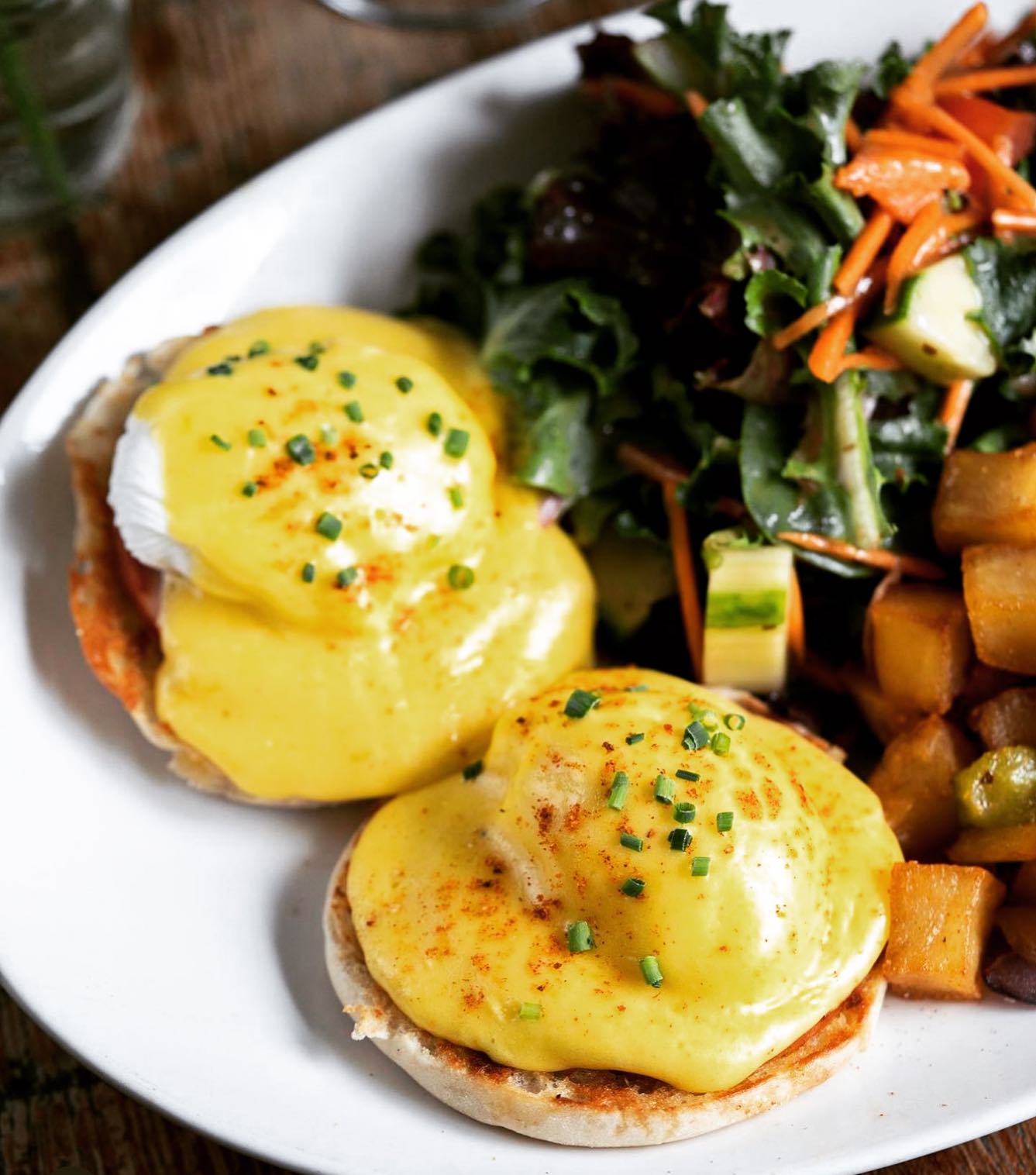 a plate of eggs benedict and salad