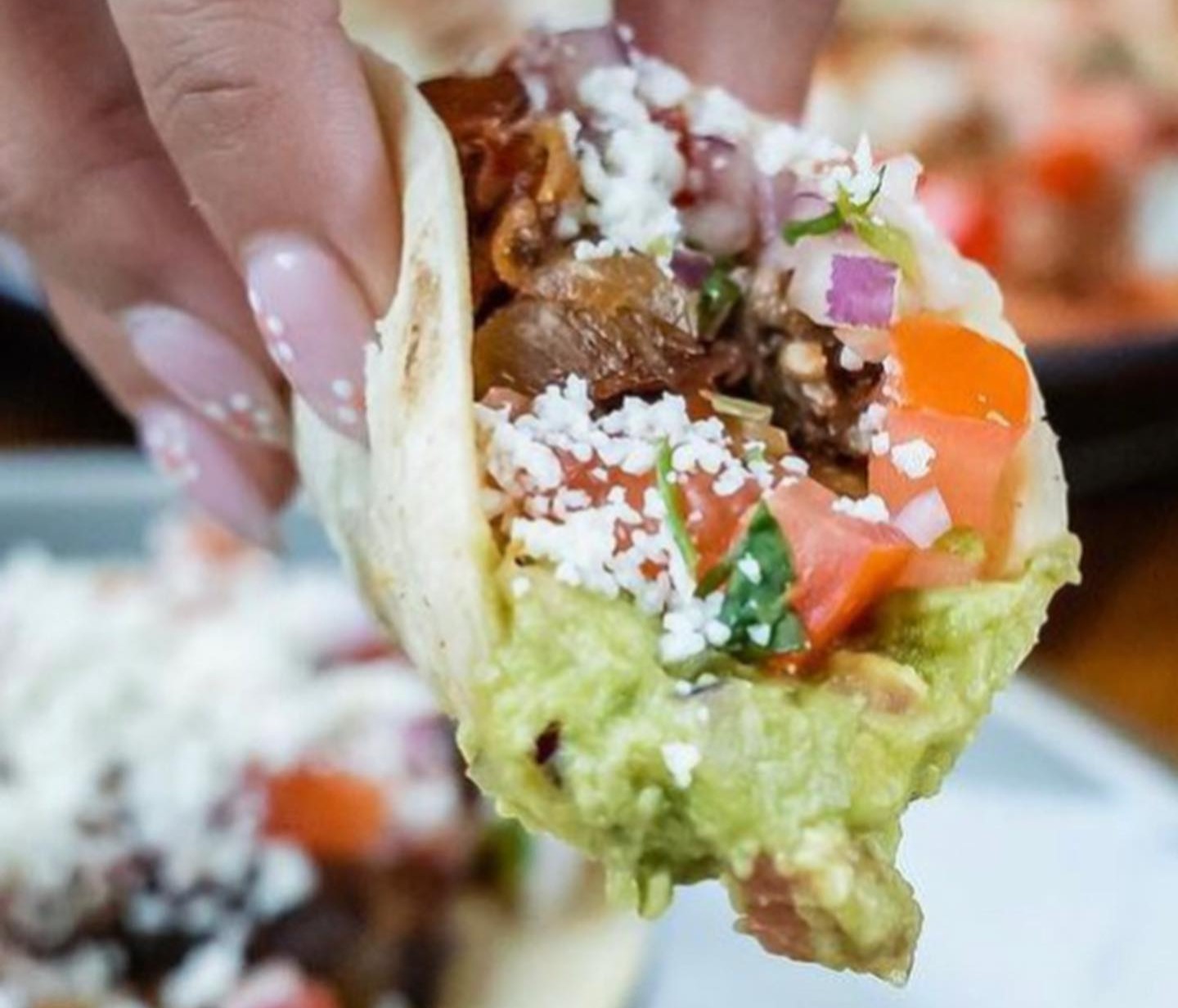 a person holding a taco