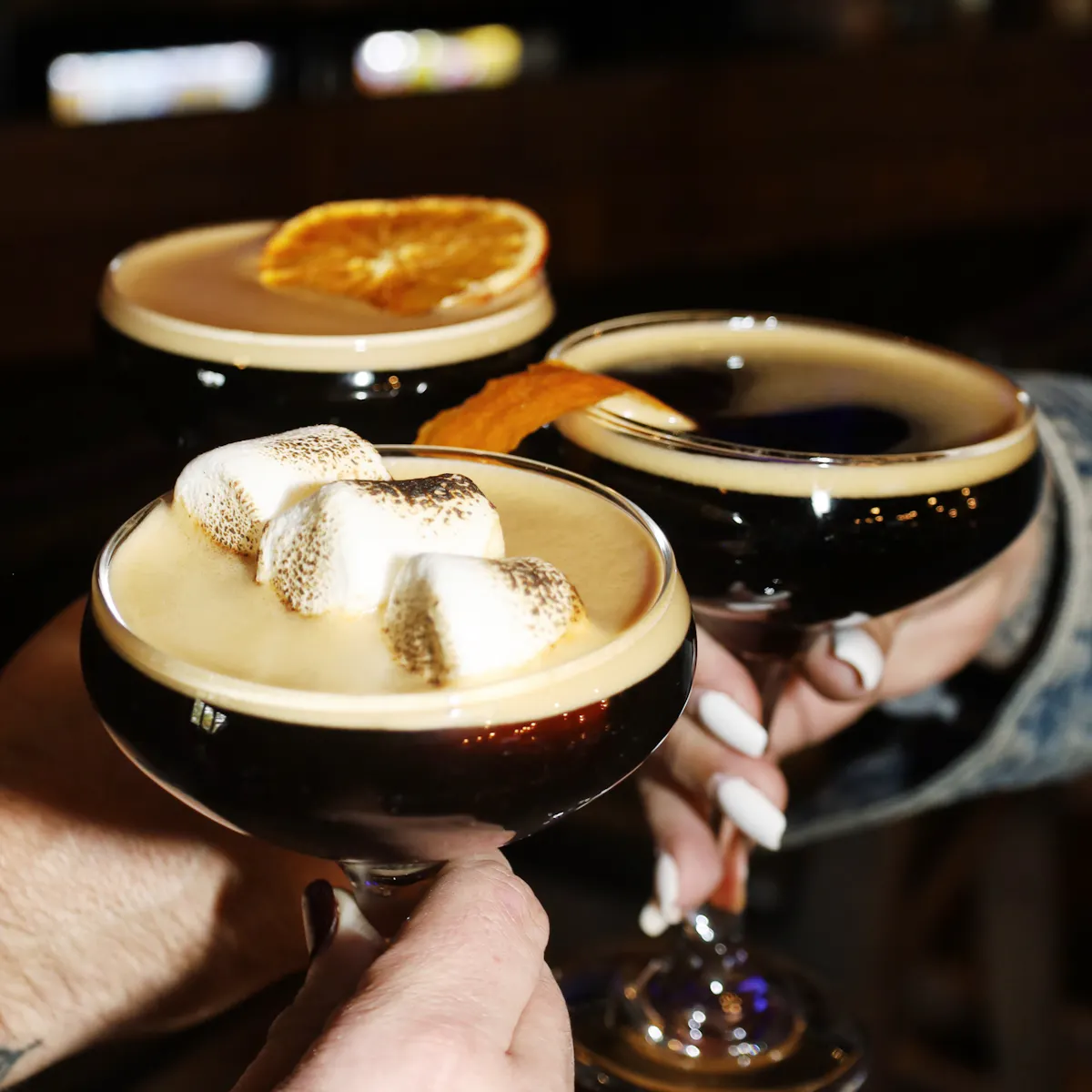 A bartender presenting cocktails at Liberty Tavern in Quincy