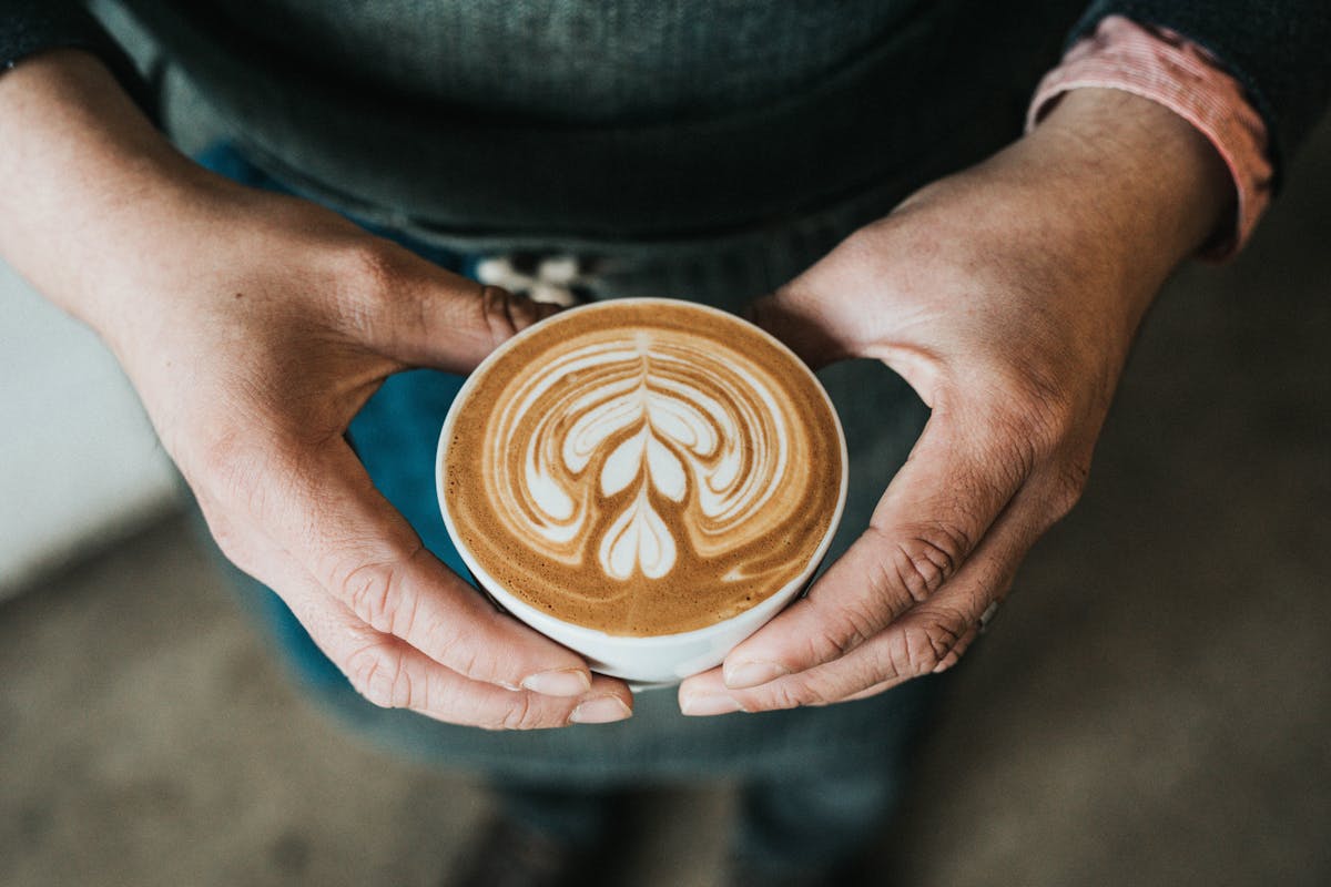 a hand holding a cup of coffee
