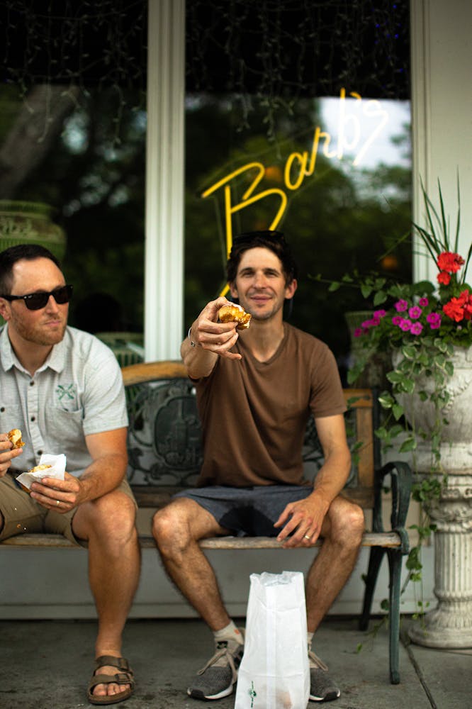 a man sitting on a bench talking on a cell phone