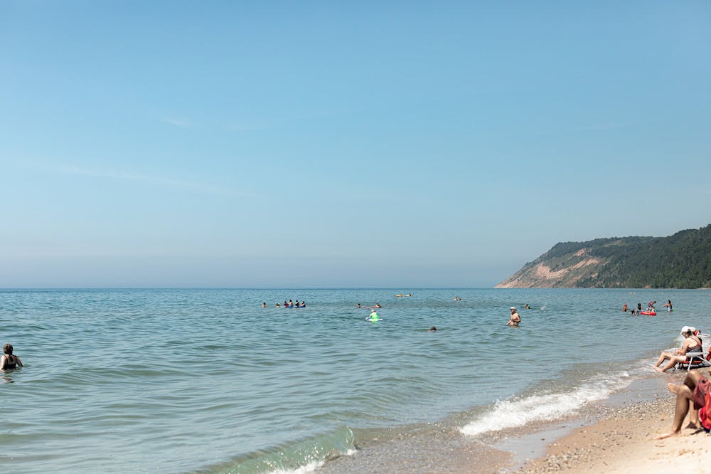 a group of people on a beach near a body of water