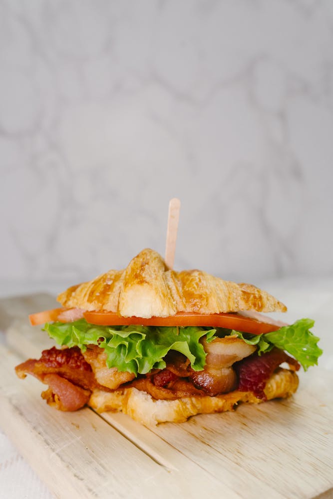 a close up of a sandwich sitting on top of a wooden cutting board