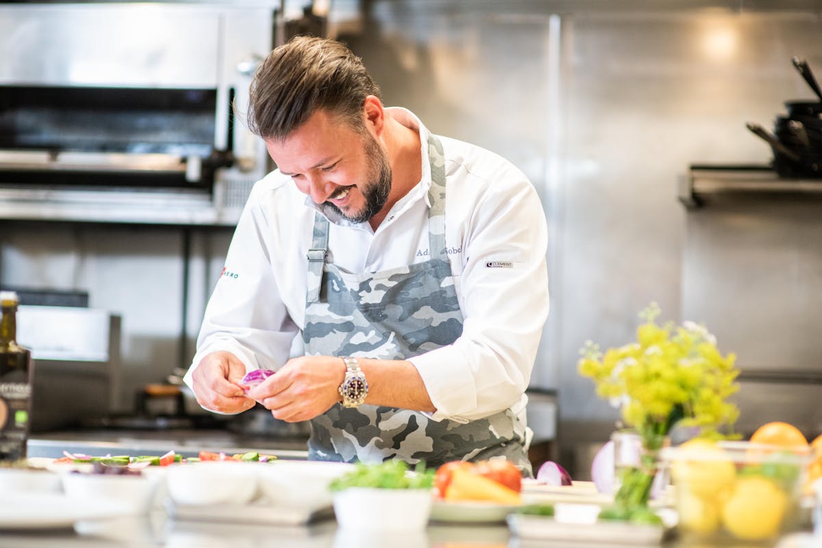 a man sitting on a kitchen counter preparing food