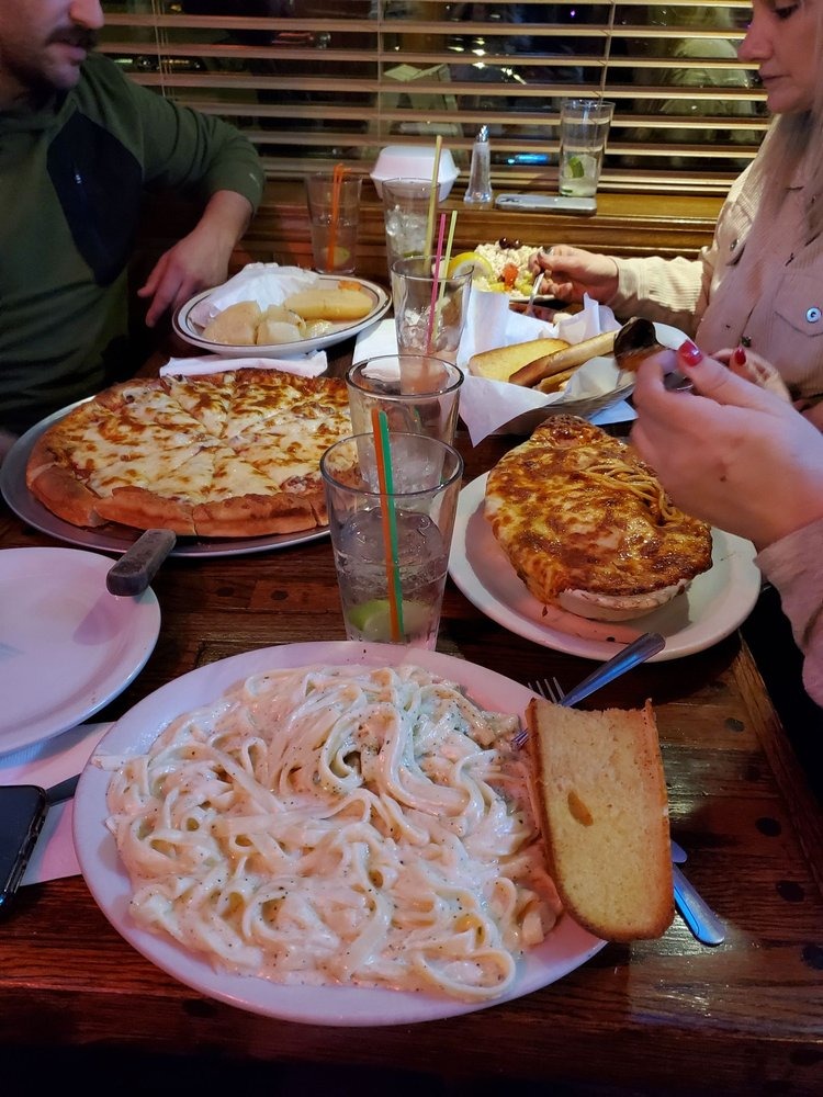 a person sitting at a table with a plate of food