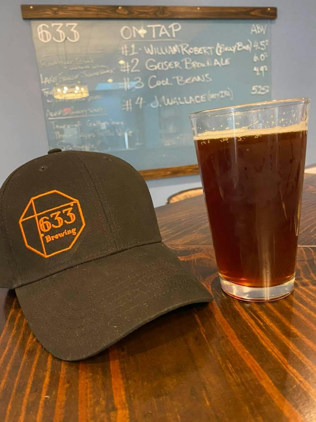 a glass of beer and a hat on a table