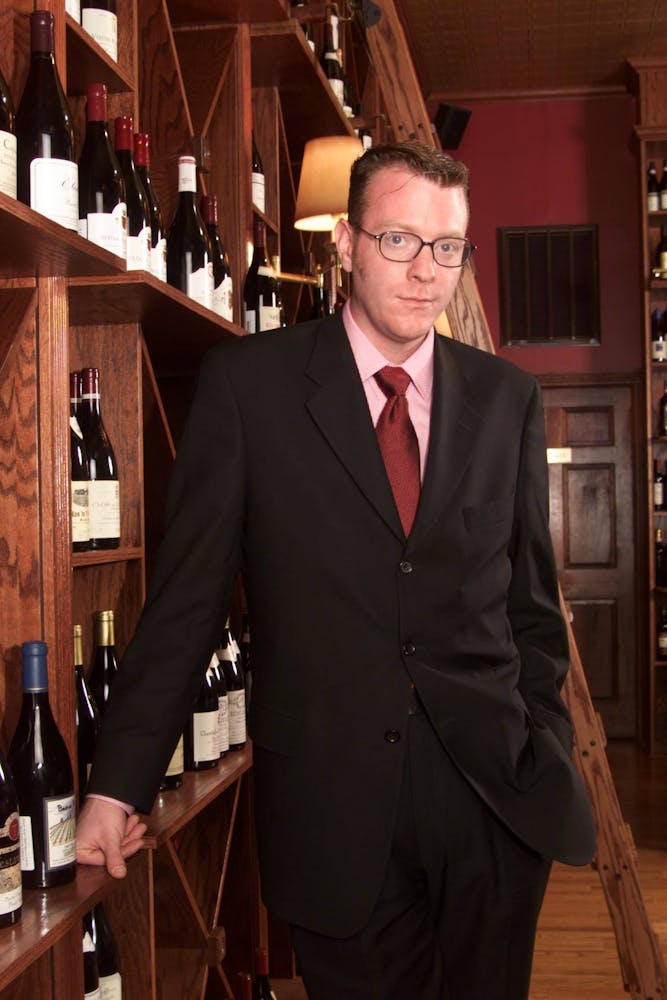 a man holding a wine glass posing for the camera
