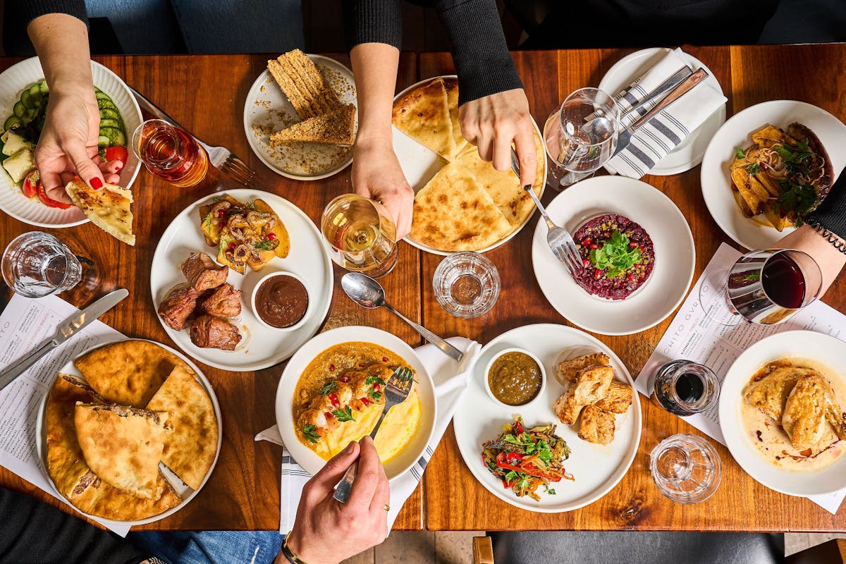 a group of people sitting at a table with a plate of food