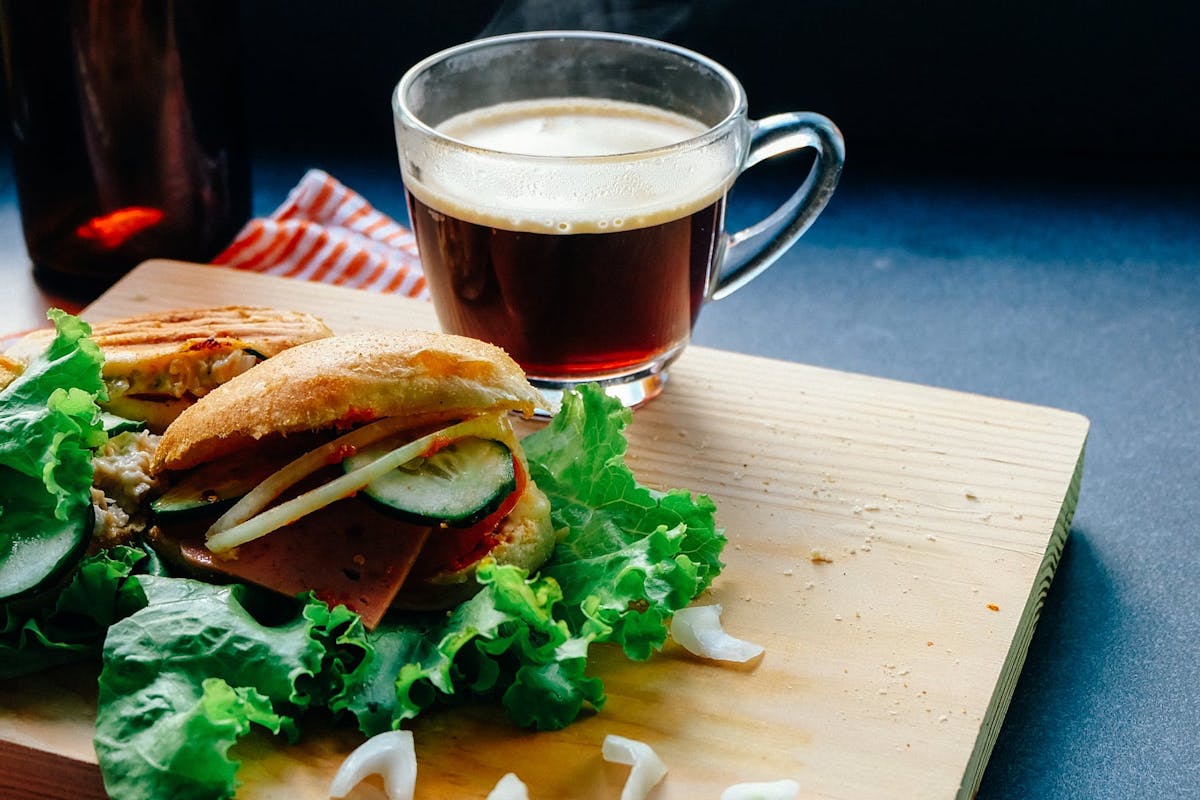 a close up of a sandwich and a cup of coffee on a table