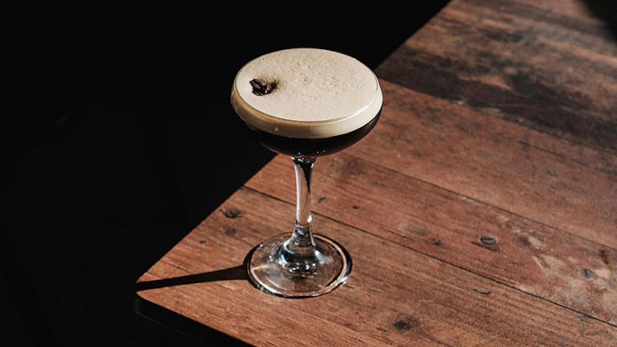 a glass of wine sitting on top of a wooden table