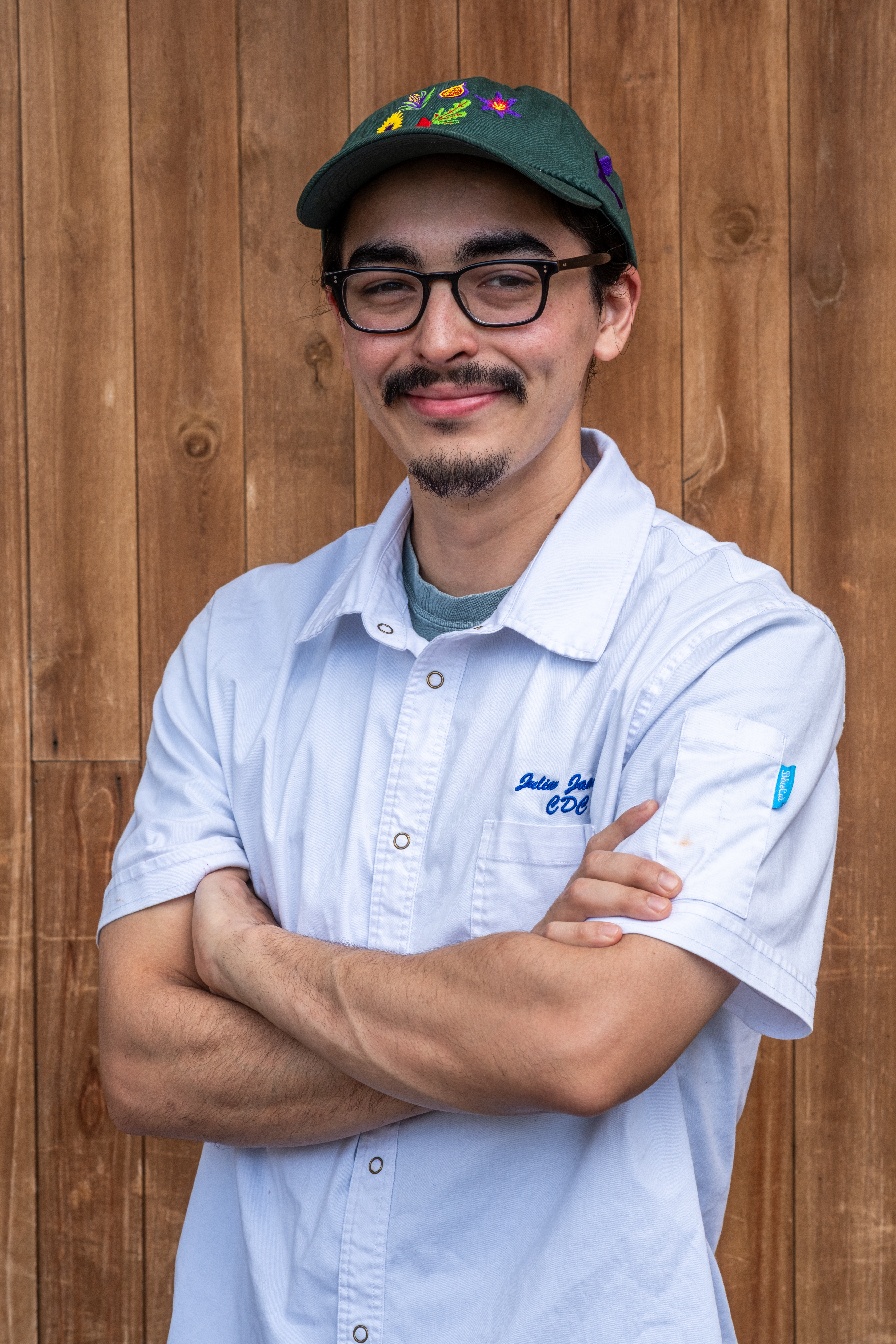 a man with a hat and glasses smiling