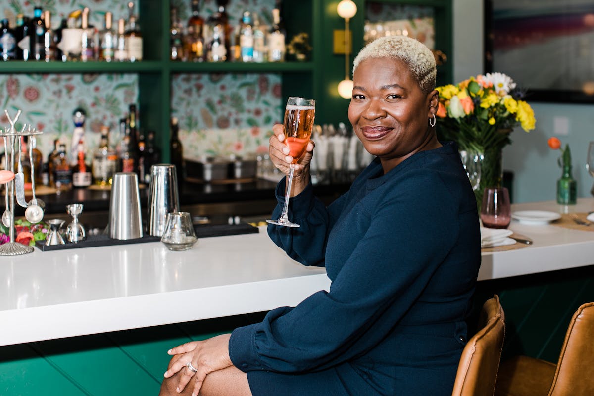 a person sitting at a table with wine glasses