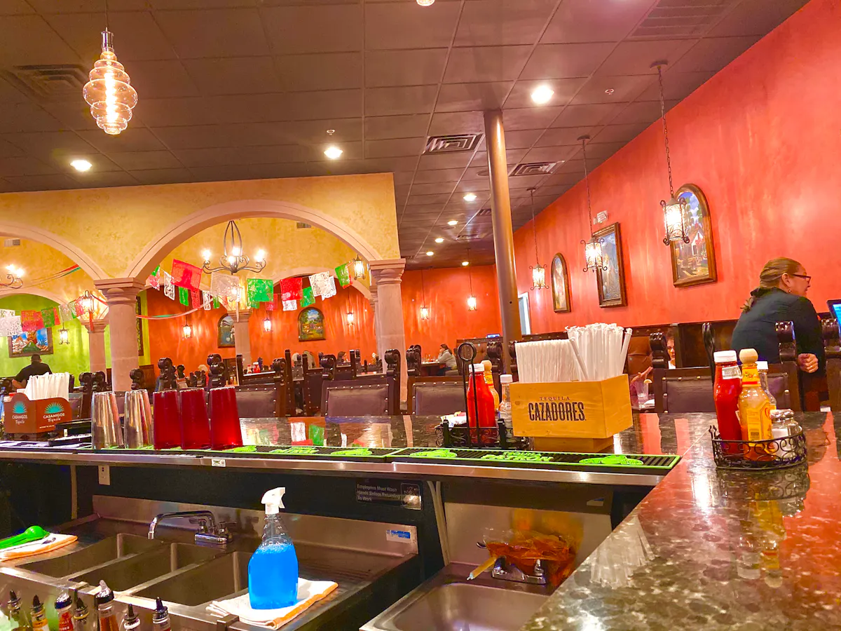 a group of people standing around a counter in a bar