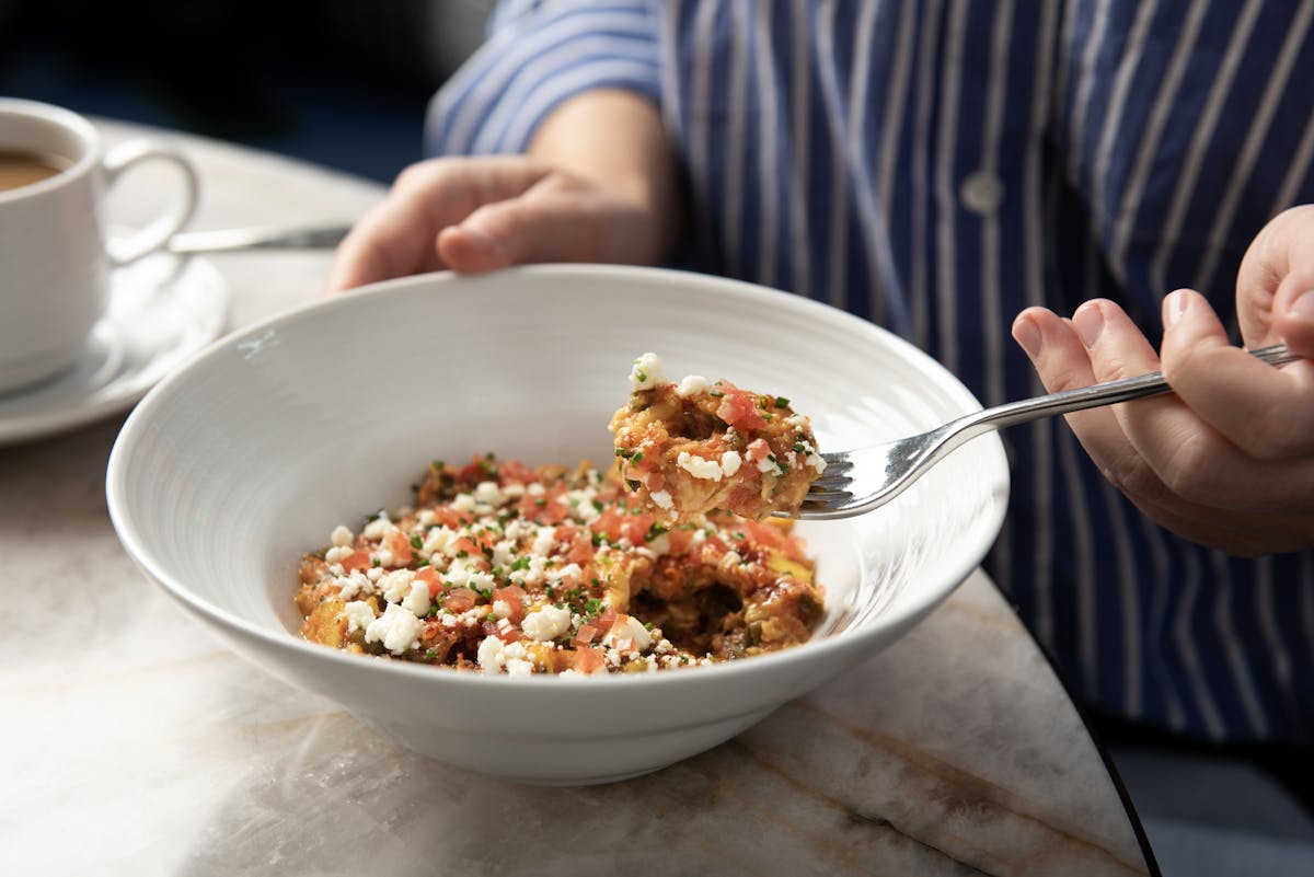 a person sitting at a table with a plate of food