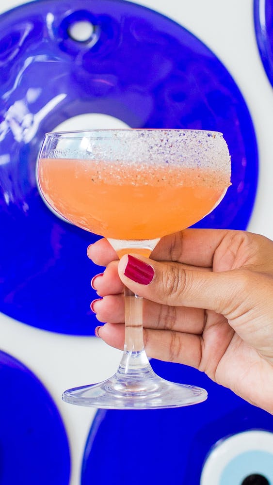 a hand holding a glass with a blue plate