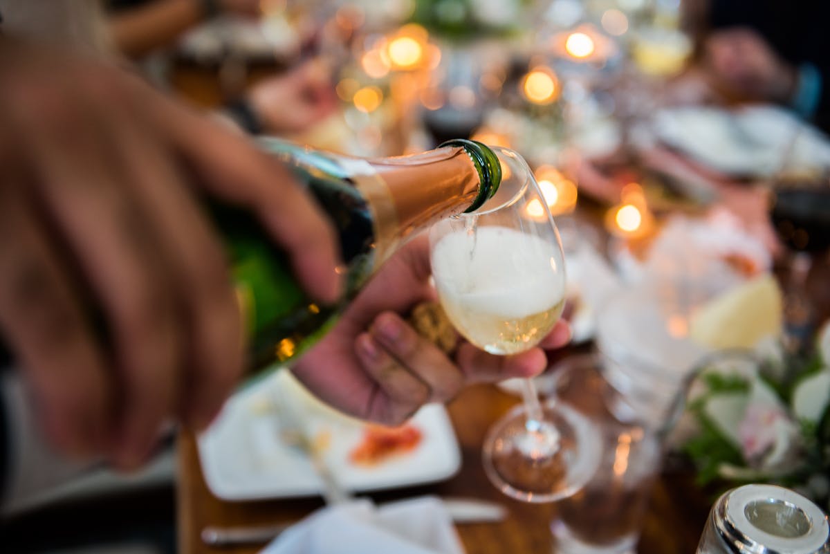 a person sitting at a table with wine glasses