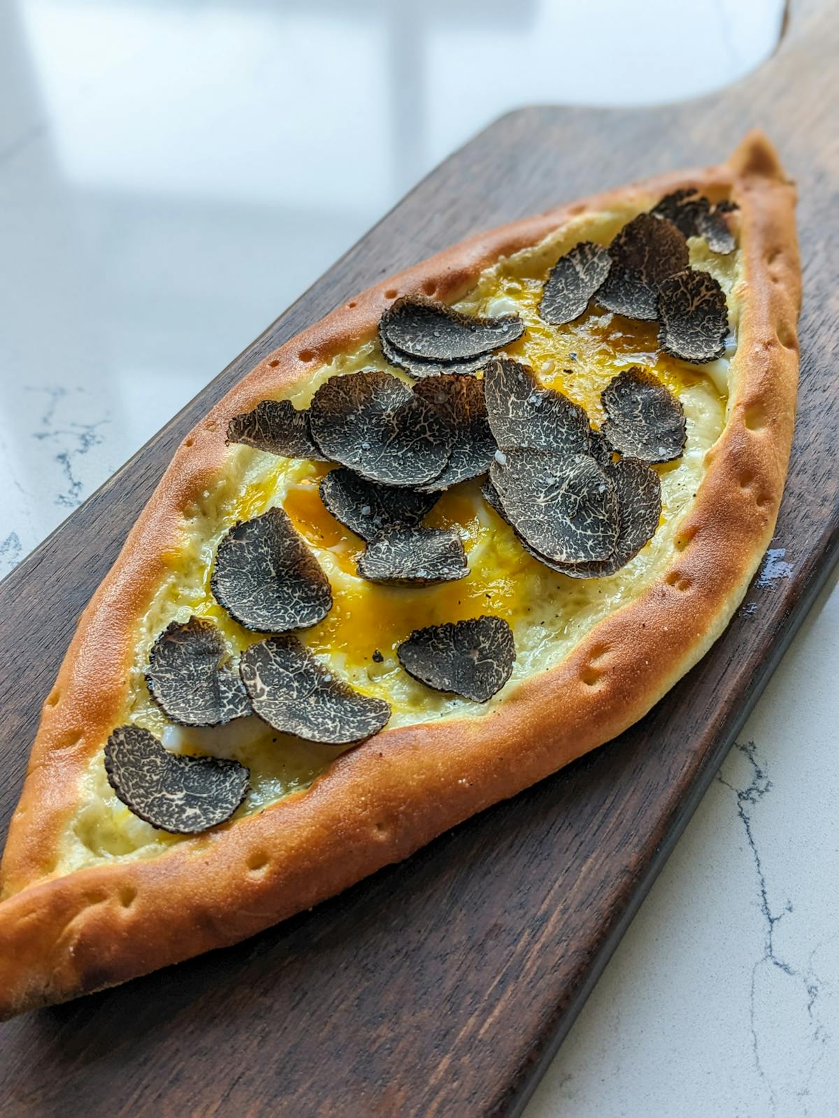a pizza sitting on top of a wooden cutting board