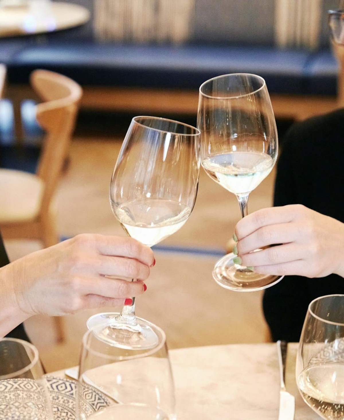 a woman sitting at a table with wine glasses