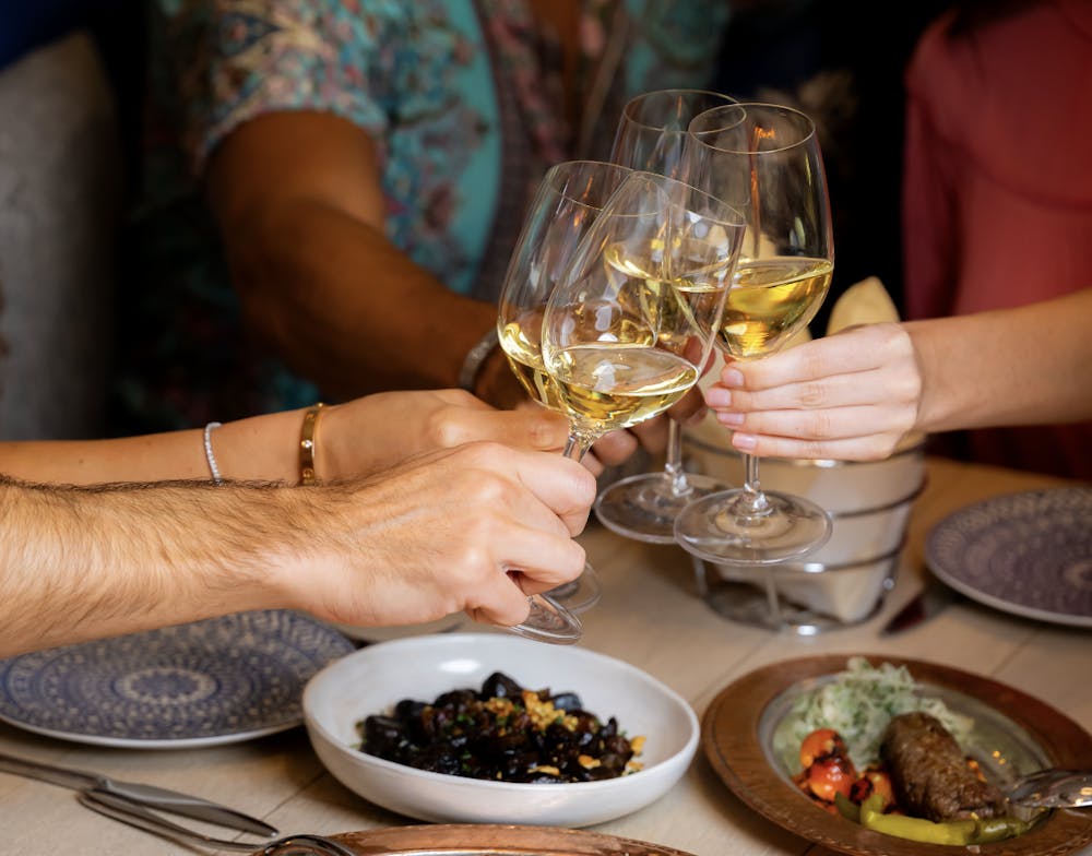 a person sitting at a table with wine glasses