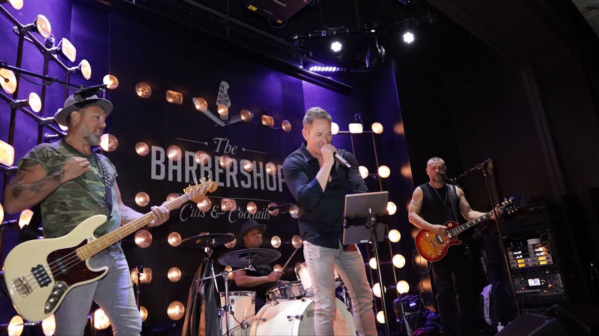 a man standing on a stage playing instruments