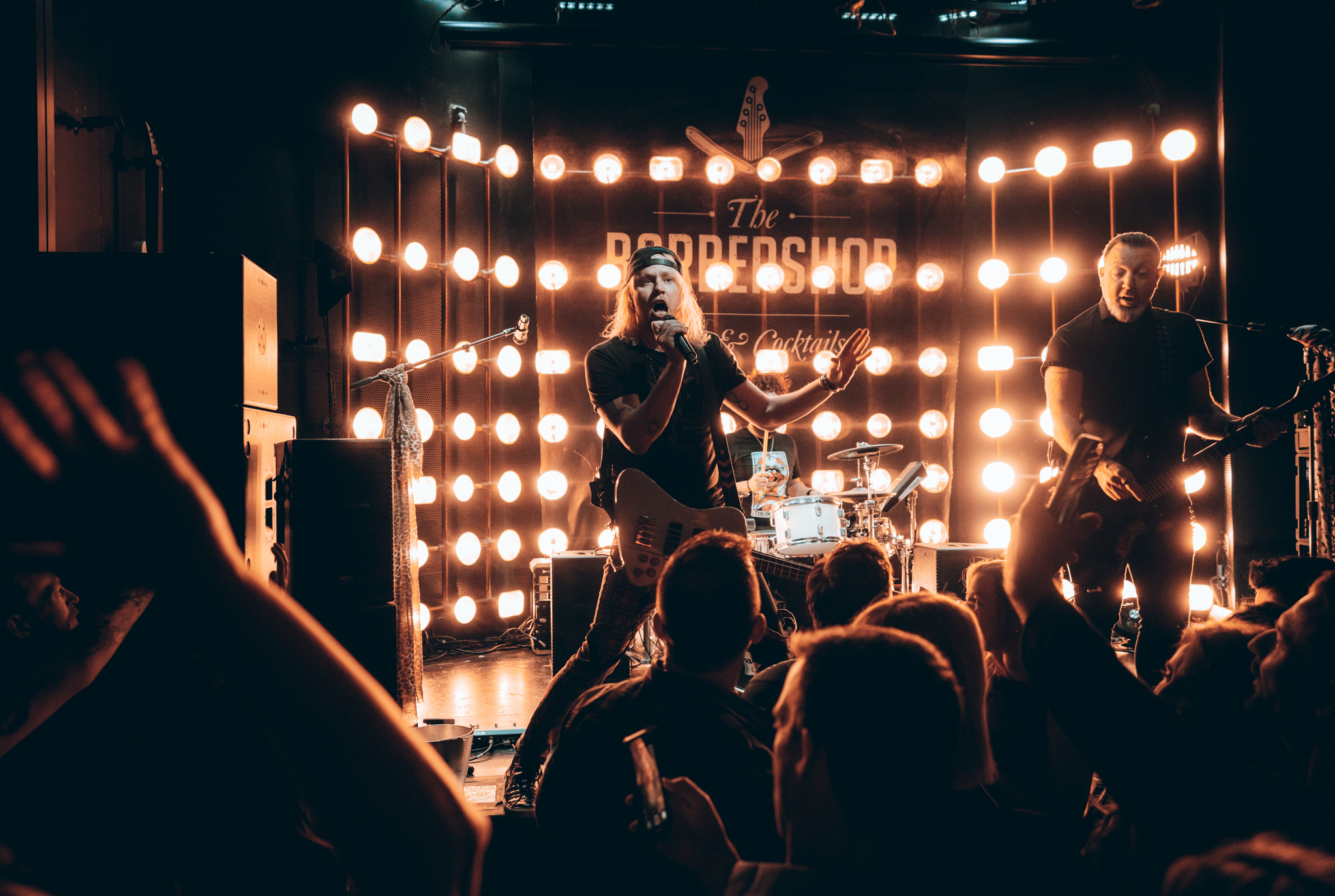 A live band performing on stage at The Barbershop, a Las Vegas speakeasy and live music venue, with the crowd up front