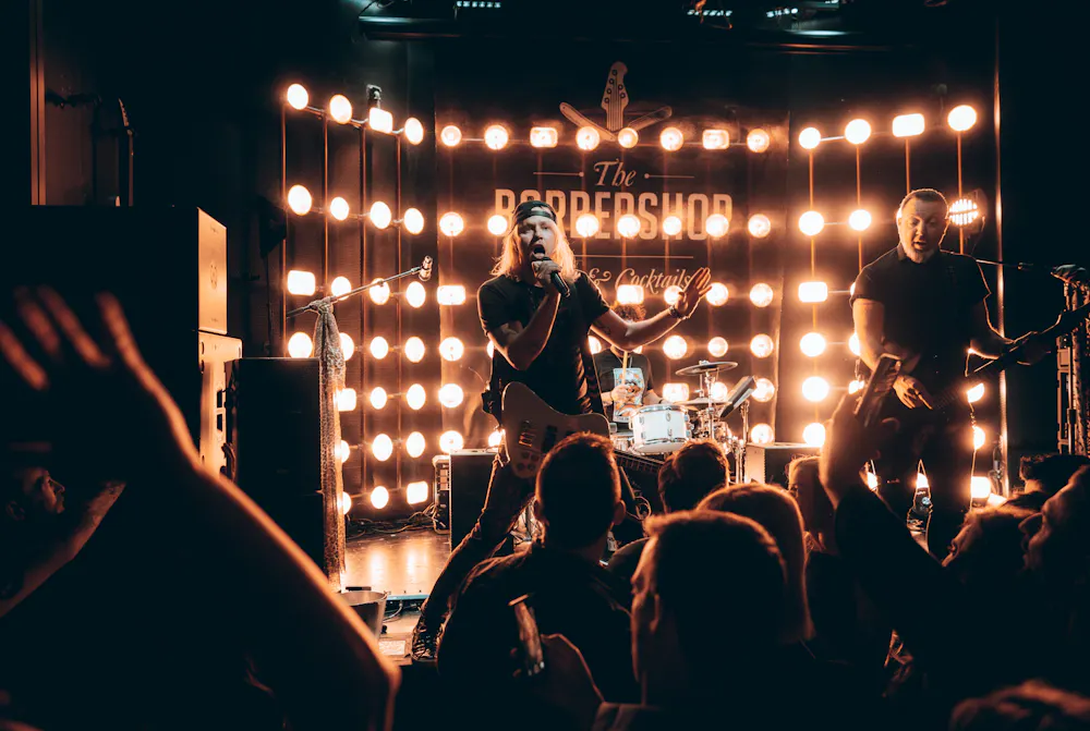 A live band performing on stage at The Barbershop, a Las Vegas speakeasy and live music venue, with the crowd up front