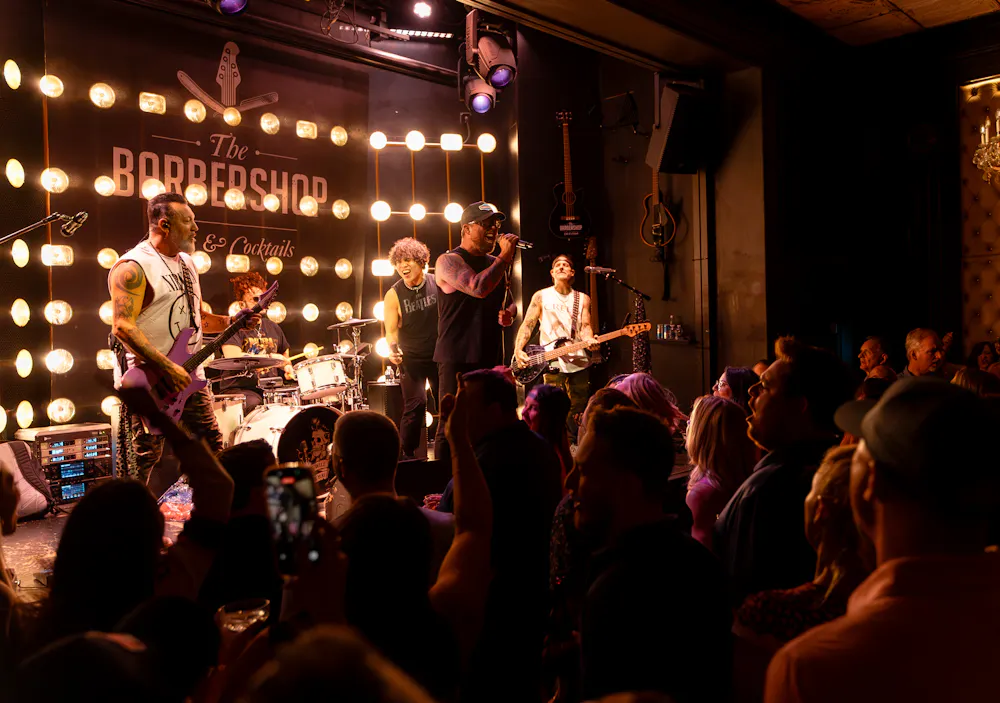Crowd raising drinks feet from the stage during a live music show at The Barbershop Las Vegas speakeasy