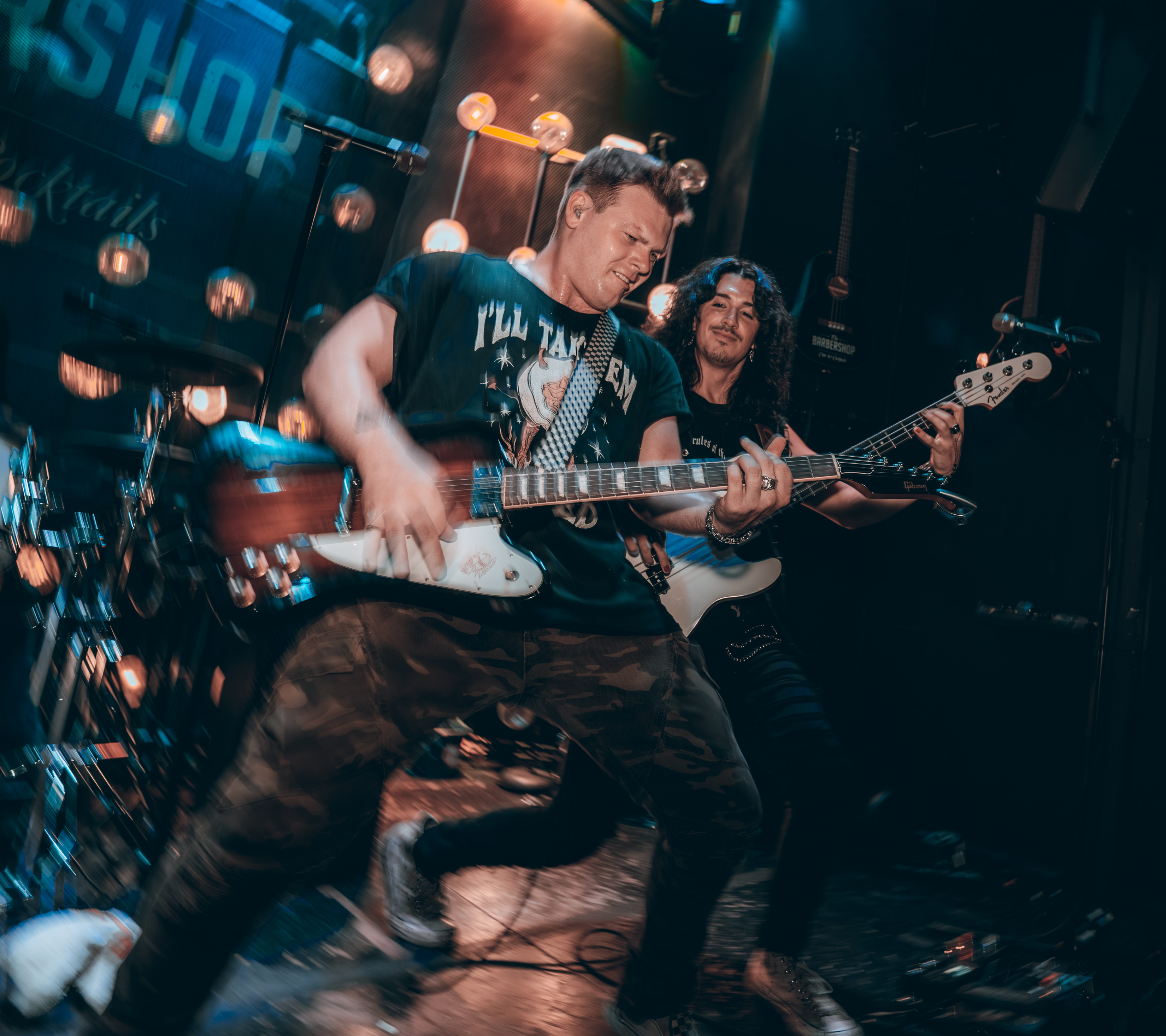 Guitarist and bassist playing a live music set on stage at The Barbershop Cuts & Cocktails, Las Vegas