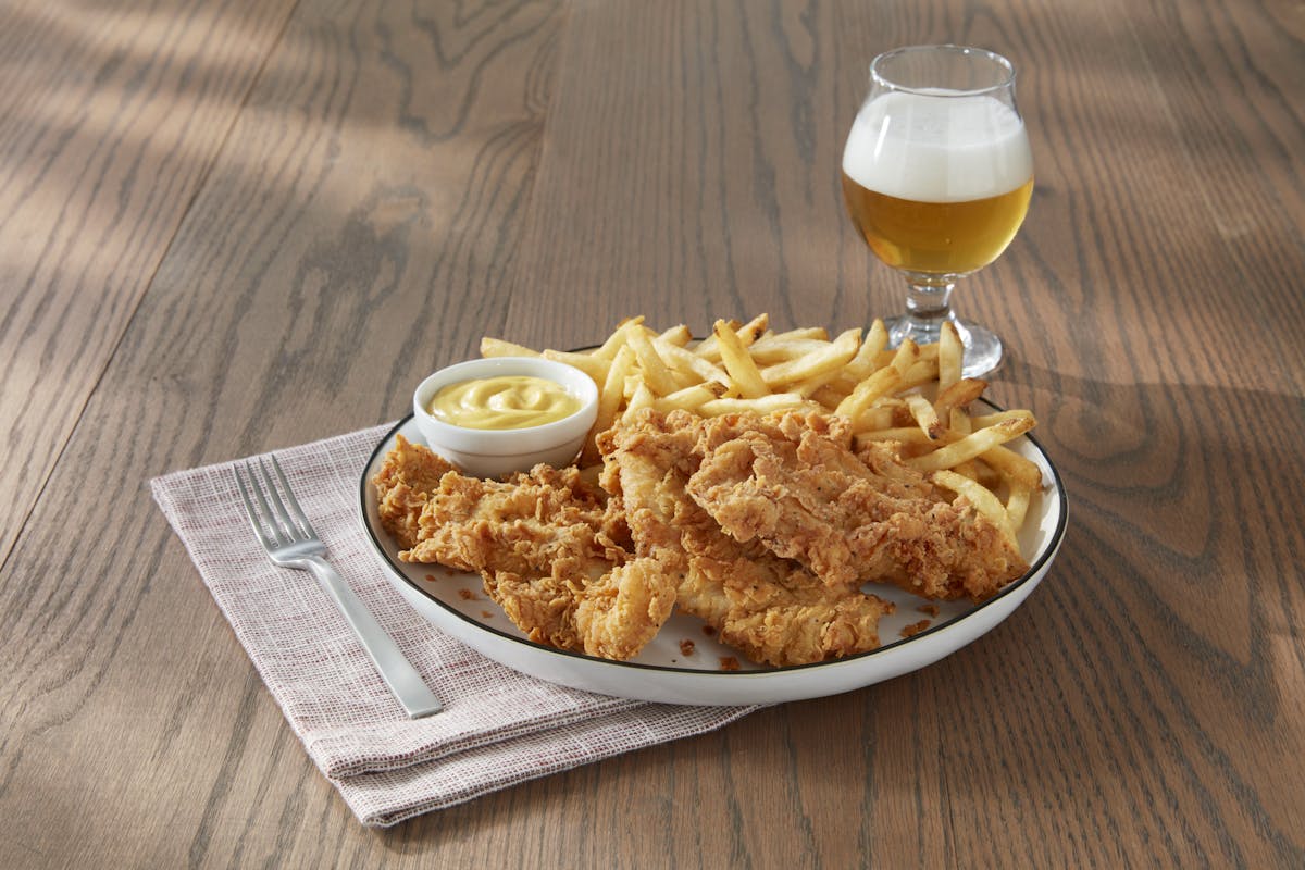 a plate of food and a glass of beer on a table