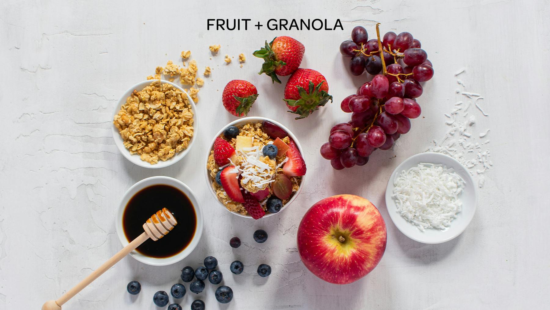 the ingredients of a fruit and granola honeybar laid out on a table