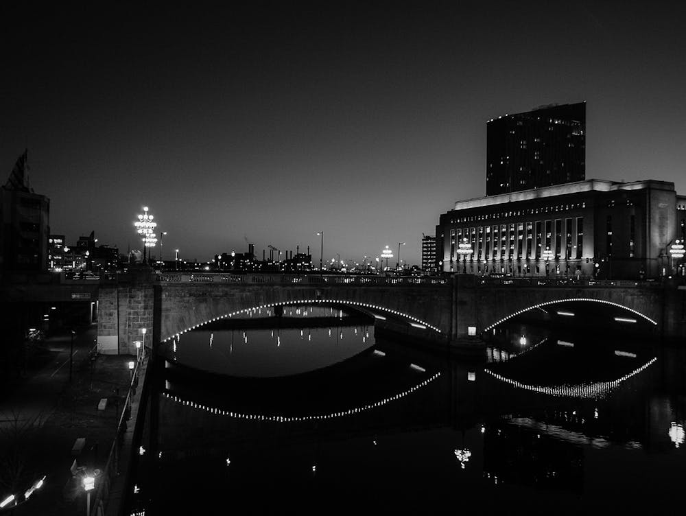 a black and white photo of a bridge and a building