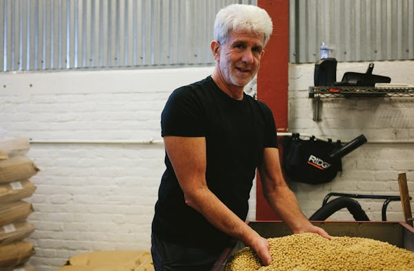 a man holding a pile of grains