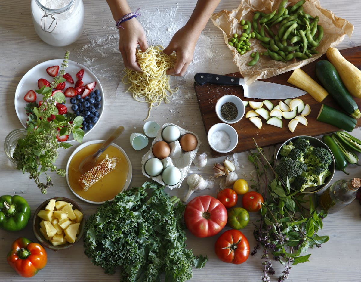 a person sitting at a table with a plate of food with broccoli