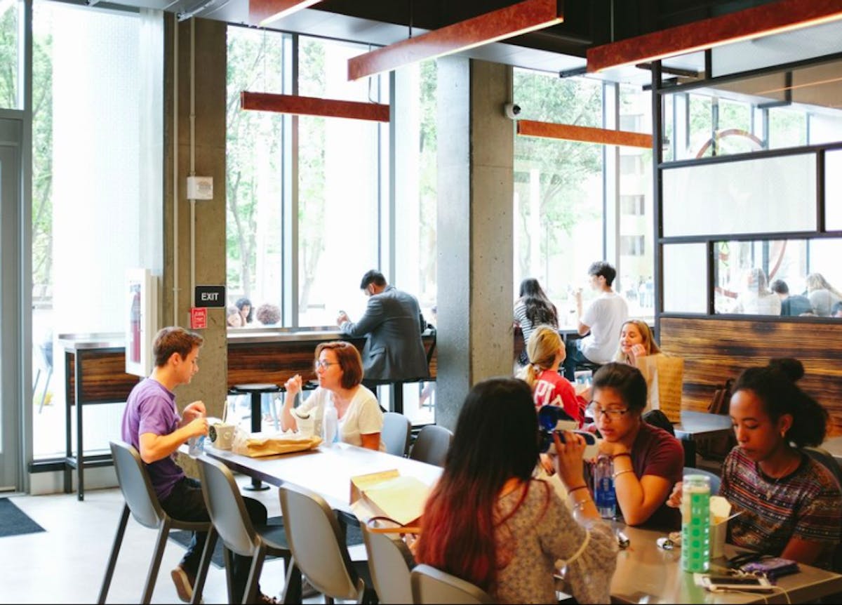 several people sitting on a dining table