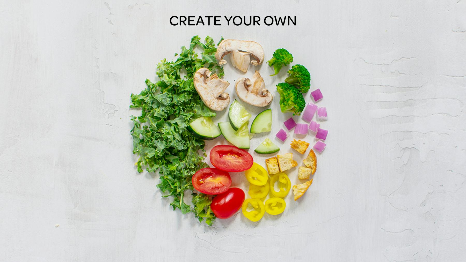 various vegetables on a table to represent a create your own salad