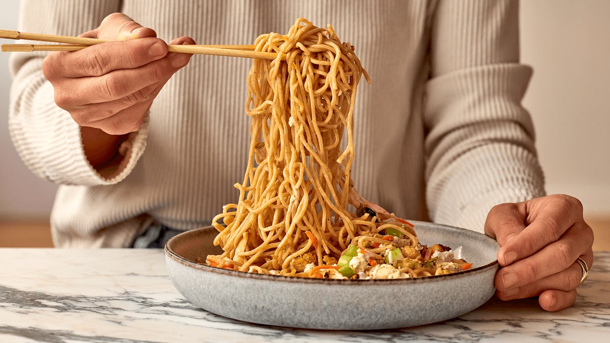 a person holding a plate of food with a knife