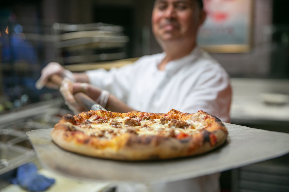 a chef showing a pizza